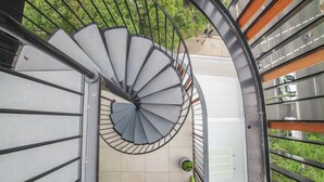 A spiral staircase with a metal railing, leading to a white door. - Inner City Penthouse With Private Rooftop (Waterloo)