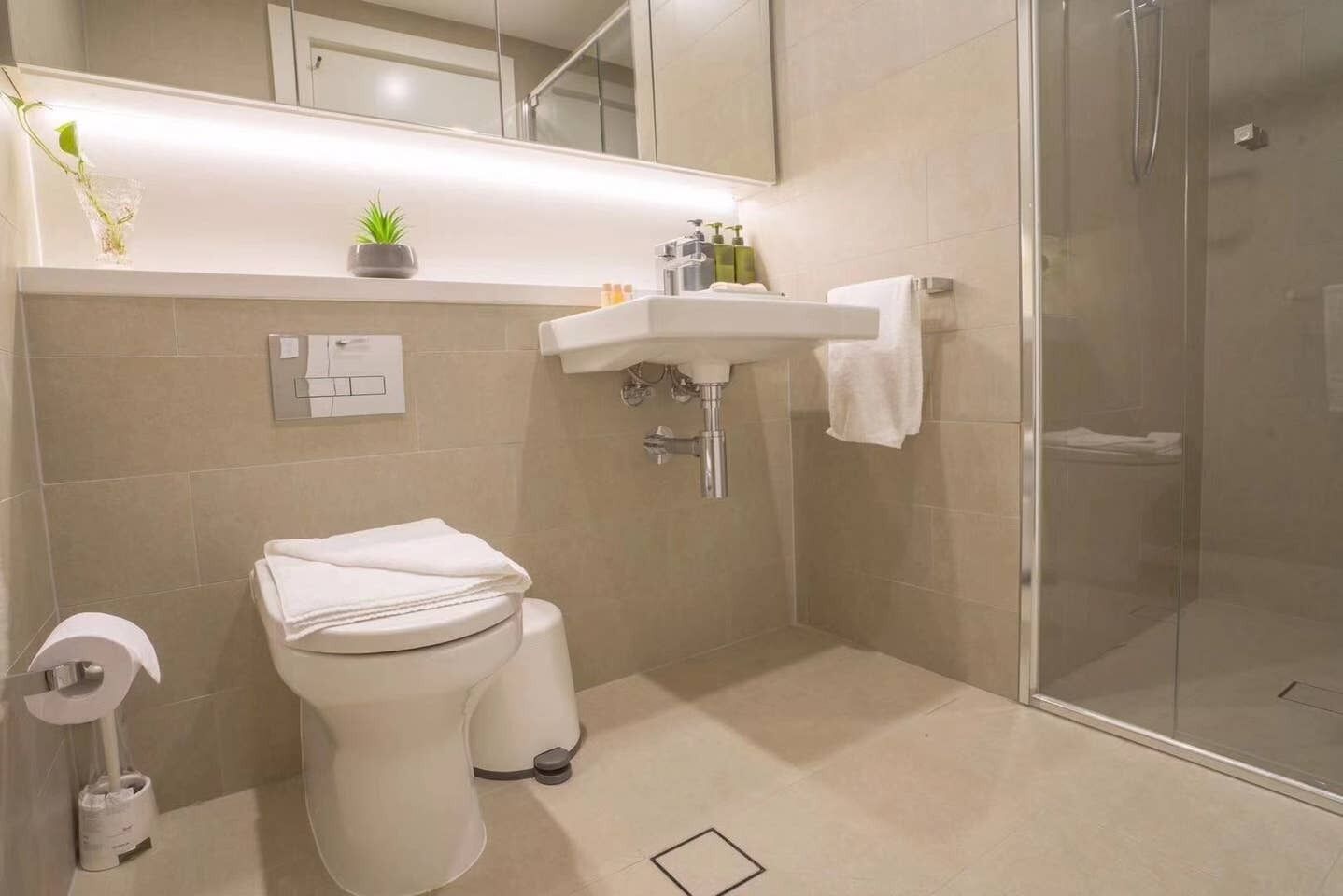 Un baño moderno con inodoro, lavabo y ducha.