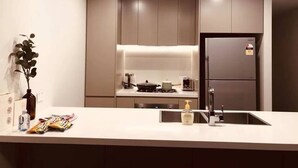 Eine moderne Küche mit Einbauofen, Kühlschrank und Spüle.
