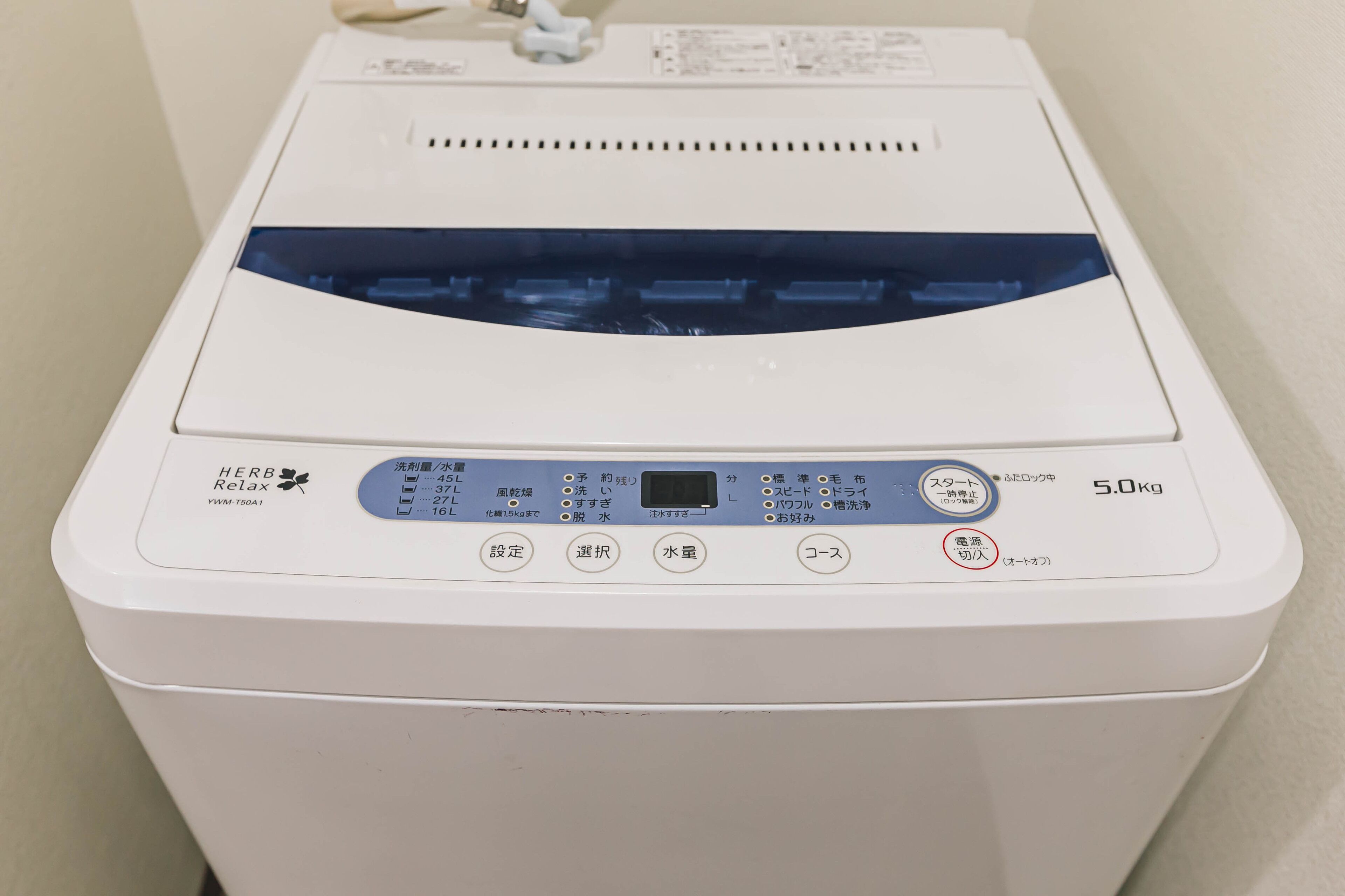 Une machine à laver blanche dotée d’un écran numérique et de boutons de commande.