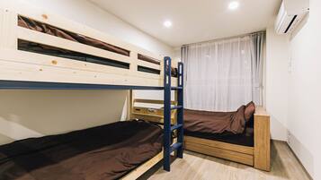 A bunk bed room with a ladder, a window with curtains, and an air conditioning unit.