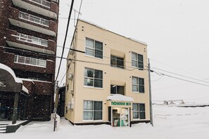 A two-story building with a sign reading "TKD HOUSE HOTEL".