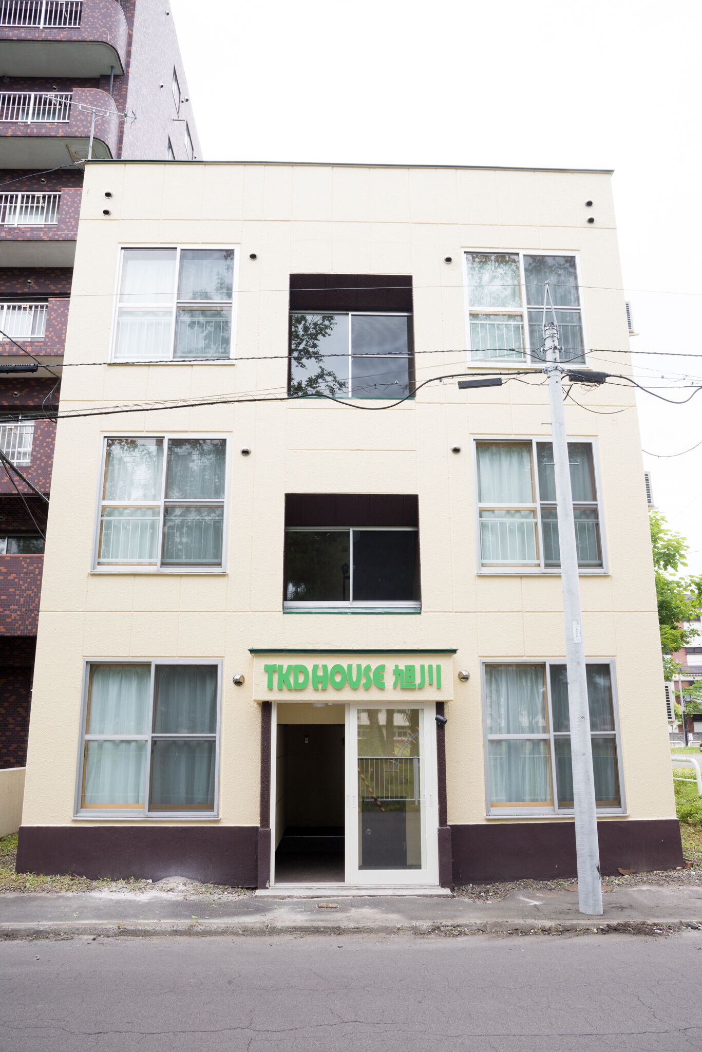 A multi-story building with a sign reading "TKD HOUSE".