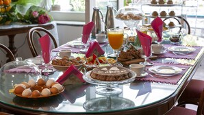 Ein Frühstückstisch mit verschiedenen Speisen und Getränken, darunter Eier, Gebäck und Orangensaft.