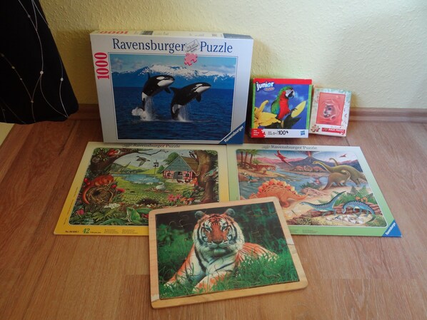 A Ravensburger Puzzle box and three puzzle pieces on a wooden surface. - Urlaub mit dem Haustier im Wald (Rostock-Wiethagen)