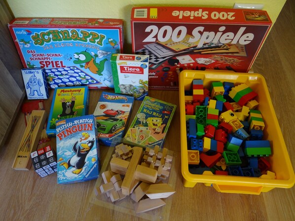 A variety of children's games and toys, including a box of 200 dice, a Scrabble game, and a collection of building blocks. - Urlaub mit dem Haustier im Wald (Rostock-Wiethagen)