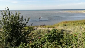 Ett kustlandskap med utsikt över havet och en avlägsen strand.