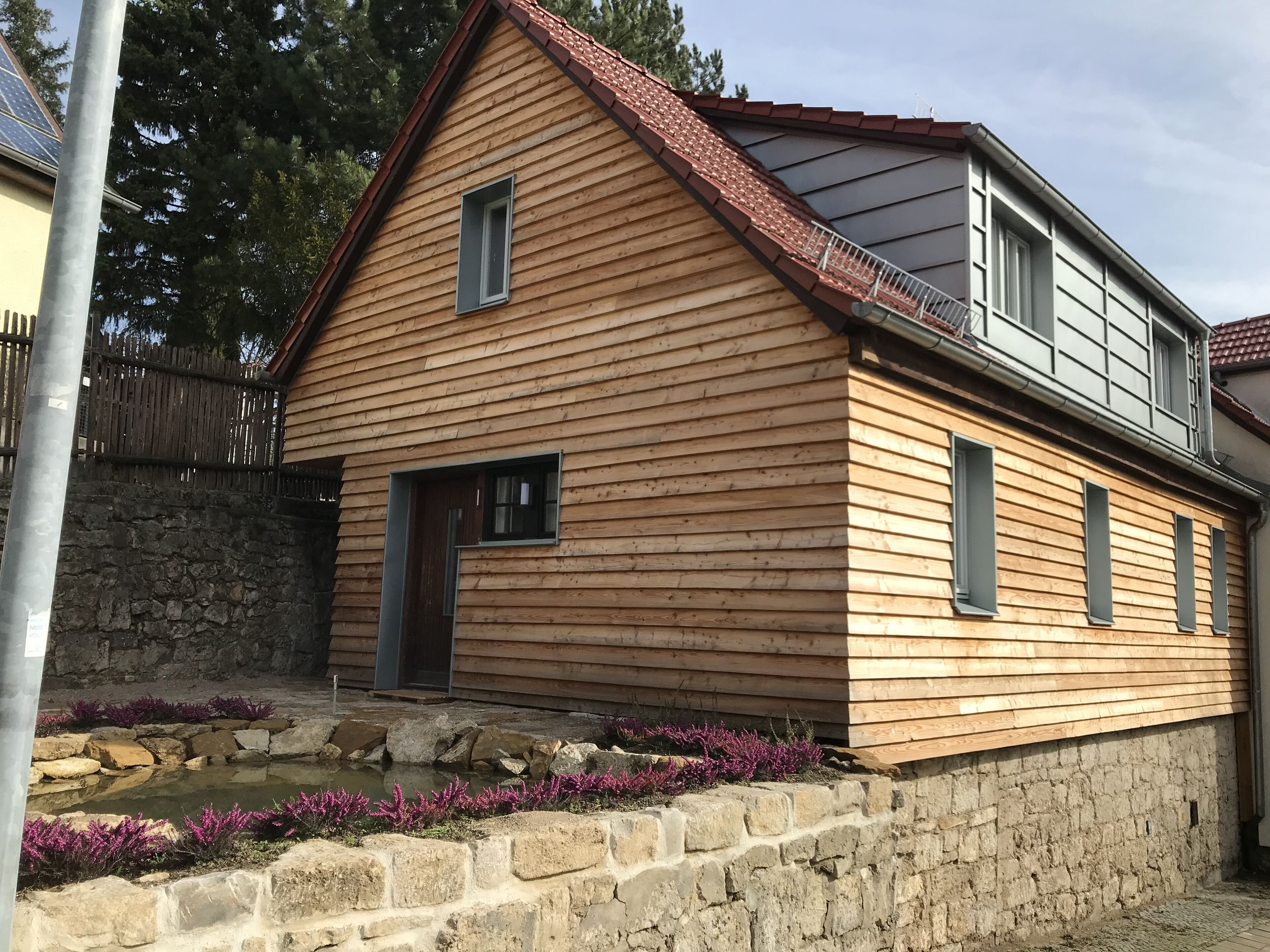 Holzhaus auf der Mauer mit Teich 