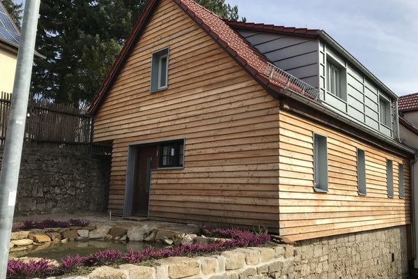 Holzhaus auf der Mauer mit Teich
