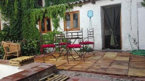 Relax in this charming outdoor seating area with a wooden deck, metal table, and comfortable chairs.