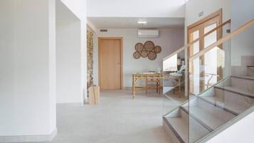 Um interior moderno com escada, área de jantar e ar condicionado de parede.