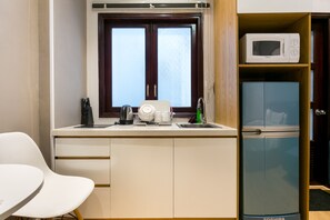 A compact kitchenette with a microwave, a toaster, and a sink. - The Art - Sunshine Ben Thanh (Ho Chi Minh City)