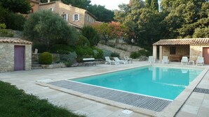 A swimming pool with lounge chairs, a stone building, and surrounding greenery. - Charming 3-bedroom home with a private pool at the foot of Mont Ventoux. Stunning view (Bédoin)