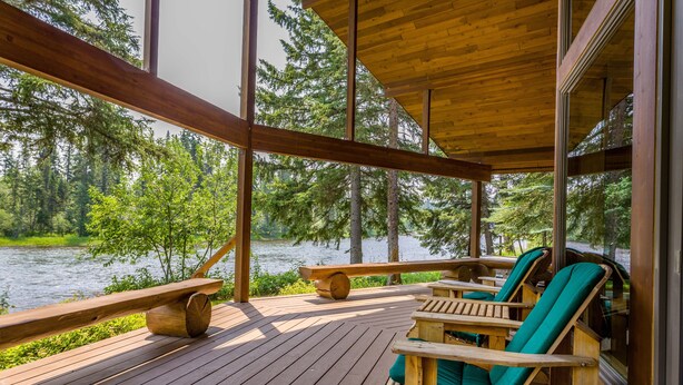 Une terrasse en bois offrant une vue sur un lac et une forêt.