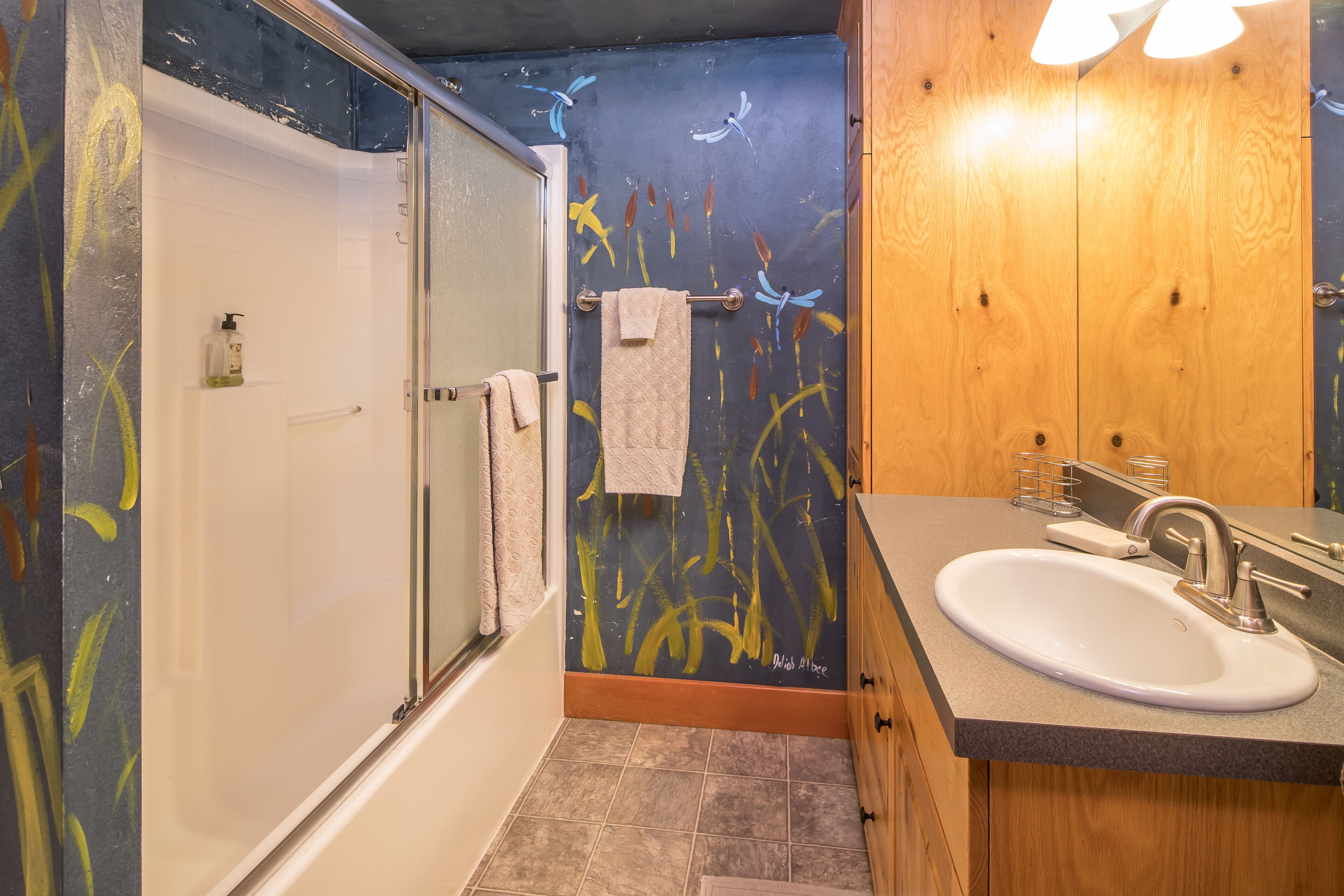 Une salle de bain avec une baignoire, un lavabo et un meuble-lavabo en bois.