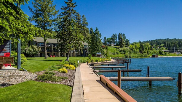 Une promenade au bord du lac, avec des quais, une pelouse et un bâtiment doté de nombreux balcons.