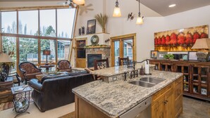 Une cuisine spacieuse dotée de plans de travail en granit, d’armoires en bois et d’un grand îlot central.
