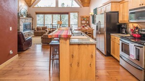 Un'ampia cucina con mobili in legno, una grande isola e elettrodomestici in acciaio inossidabile.
