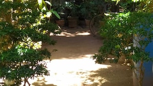 A garden pathway with potted plants and a rustic structure in the background. - AWON Hotel (Mirissa)