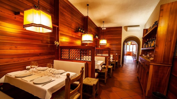 Un restaurante con paredes y mesas de madera dispuestas para comer.