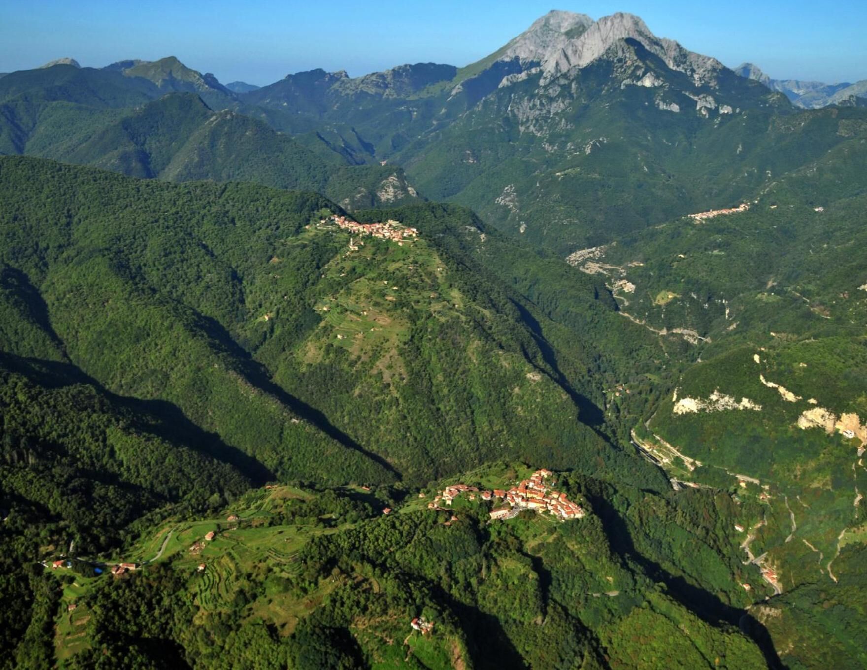A mountainous landscape with terraced fields and scattered buildings.