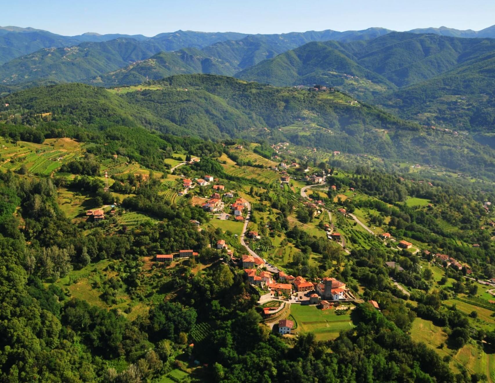 Un village rural avec des champs en terrasses et des maisons dispersées.
