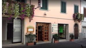 Un edificio con un letrero que dice 'elisco' restaurante, una puerta de madera y macetas con flores colgantes.