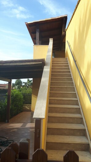 A staircase leading up to a building with a yellow exterior wall.