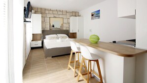 A small, modern bedroom with a bed, a nightstand, and a desk with two chairs. There is a window on the left side. - Villa Rajski Dvor1 (Bol)