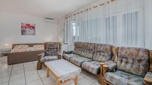 Ein Wohnzimmer mit einer Sofagarnitur, einem Couchtisch und einem gemusterten Teppich.