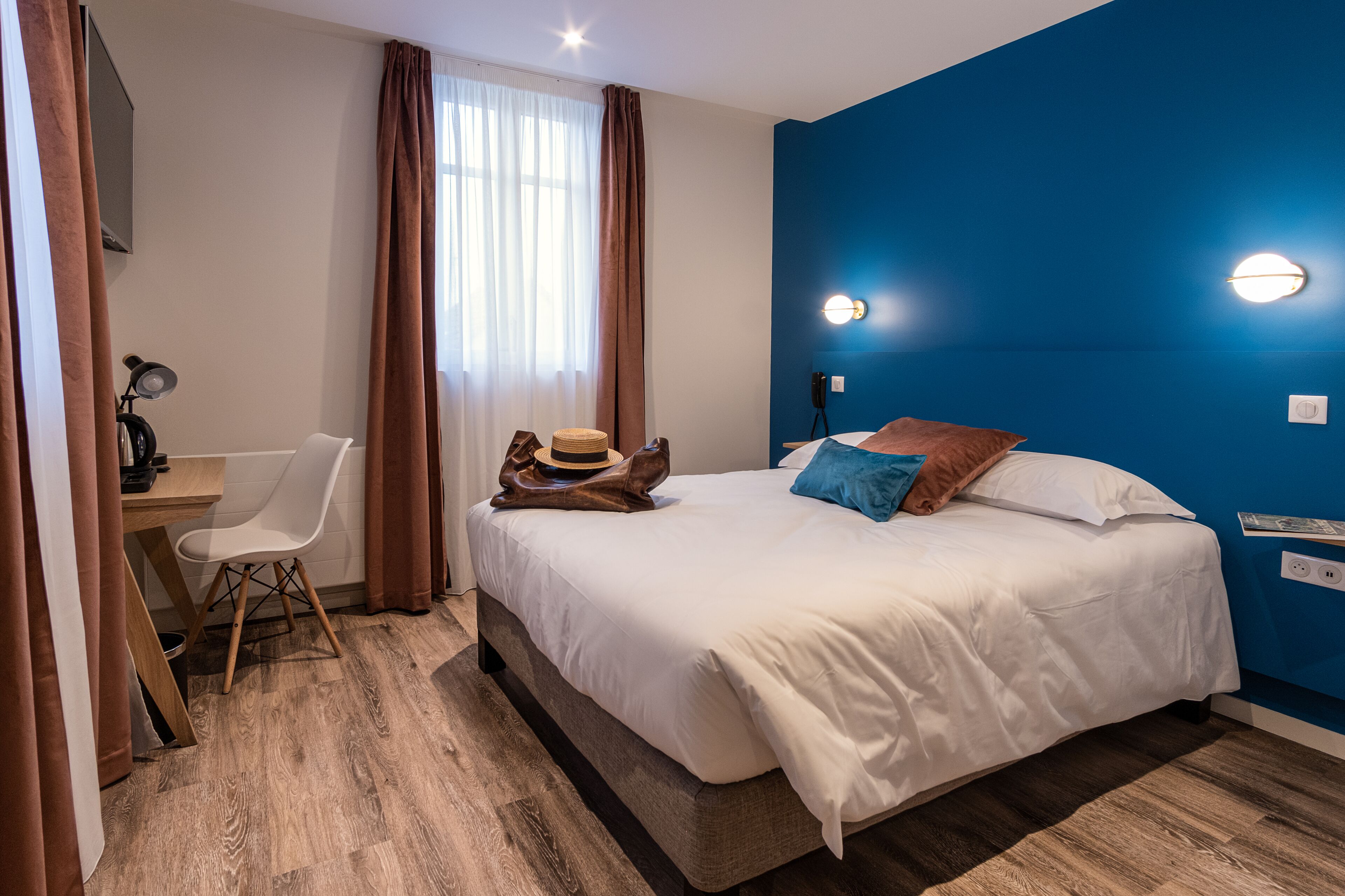 Une chambre d’hôtel avec un lit, un bureau et une chaise.