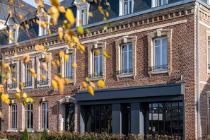 A multi-story brick building with large windows and a modern entrance. - Mayrena Hotel (Eu)