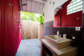A bathroom with a stone sink, red curtains, and a bamboo fence outside. - Villa Mason 9 Bedroom (Seminyak)