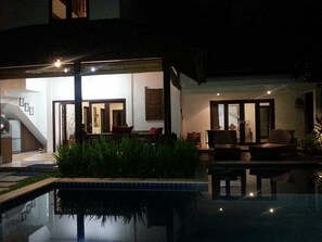 A modern house with a swimming pool, outdoor seating, and a staircase leading to the interior. - Villa Mason 9 Bedroom (Seminyak)