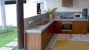 Uma cozinha moderna com bancada de granito, eletrodomésticos de aço inoxidável e armários de madeira.
