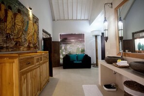A modern bathroom with a wooden vanity, a large mirror, and a stone sink.