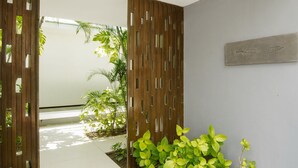 A modern interior with a white ceiling, wooden partitions, and green plants. - Villa Aqua (Seminyak)