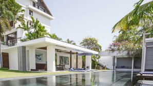 A modern house with a swimming pool, a covered patio, and a well-maintained lawn. - Villa Aqua (Seminyak)