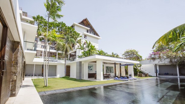A modern resort with a swimming pool, outdoor seating, and lush greenery. - Villa Aqua (Seminyak)