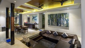 A modern living room with a sofa, coffee table, and artwork on the wall. - Villa Aqua (Seminyak)