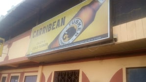 Un edificio con un cartello pubblicitario della birra 'Caribbean Cold Tusker'.