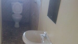 Un bagno con un lavandino bianco, un water e un pavimento decorato.