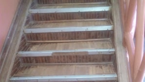 Una scala in legno con ringhiere in metallo, che conduce a un piano superiore.