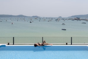 A pool with a view of a marina filled with boats.
