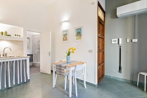 Une cuisine moderne dotée d’un îlot central intégré, de meubles blancs et d’un coin repas avec une table et des chaises.