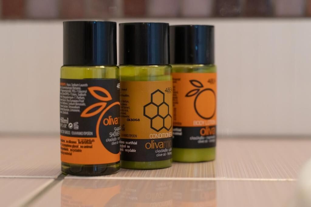 Three bottles of olive oil on a reflective surface.