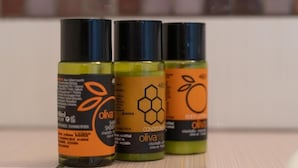 Drie flessen olijfolie op een reflecterend oppervlak.