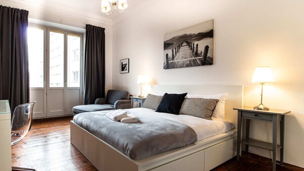 A modern bedroom with a large bed, bedside tables, a desk, and a chair. - Powisle Superior Apartment (Warsaw)