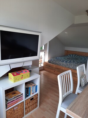 Relax in a spacious room with a large flat-screen TV, comfortable bed, and stylish seating area.