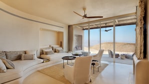 A modern living room with a curved sofa, a white armchair, and a coffee table.